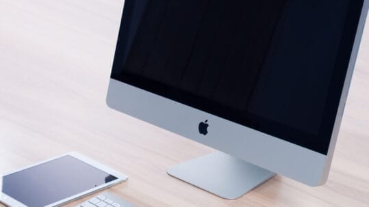 Web designer working on a creative and responsive website layout on a desktop computer with various design tools