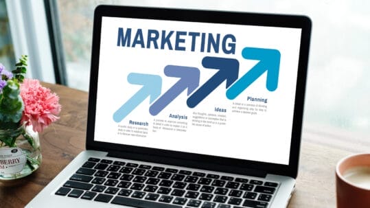 Custom web design display on a laptop screen with Naples, FL beach background